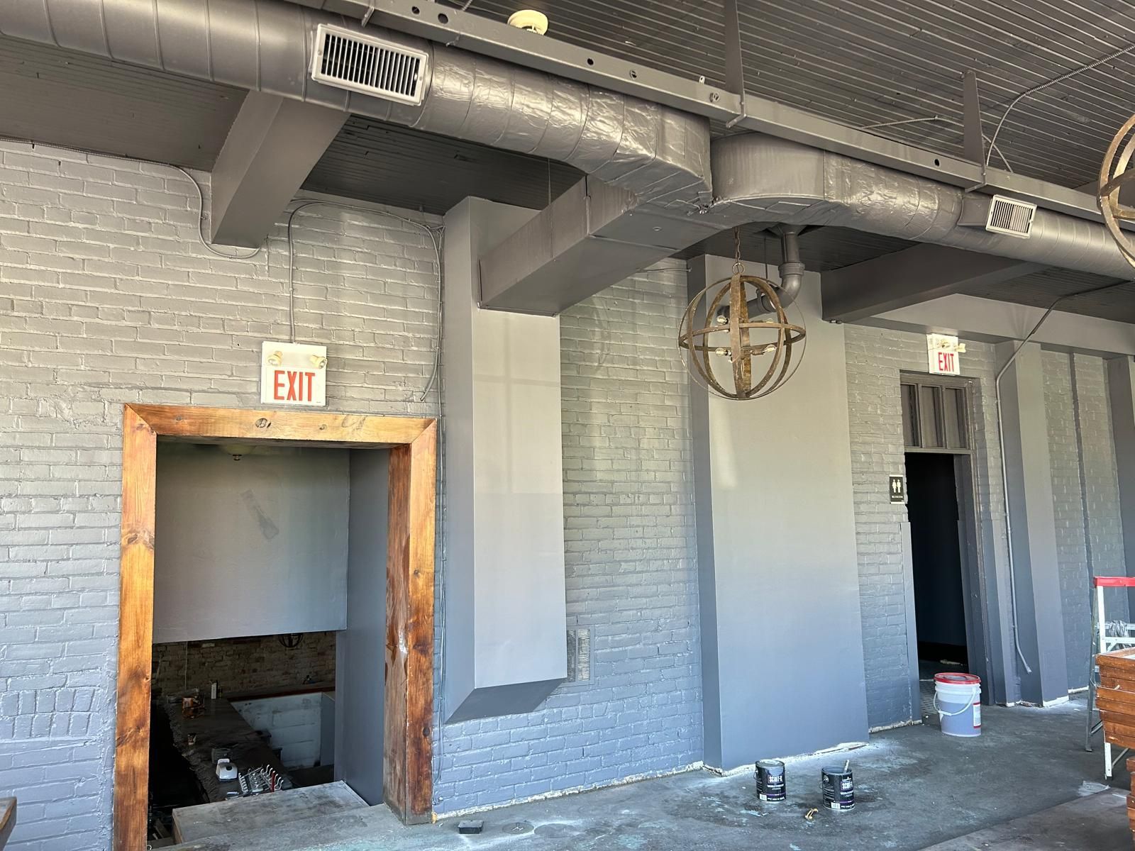 A room with a brick wall and a fan hanging from the ceiling.