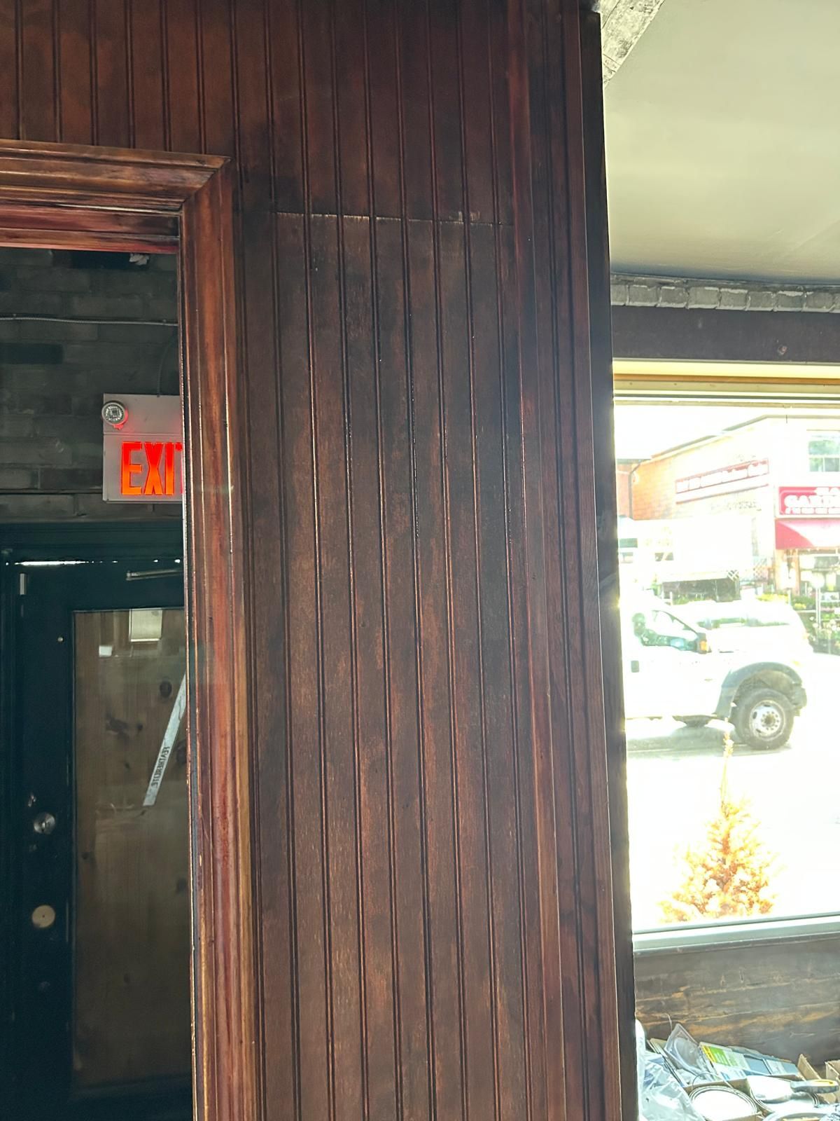 A wooden wall with a red exit sign above it