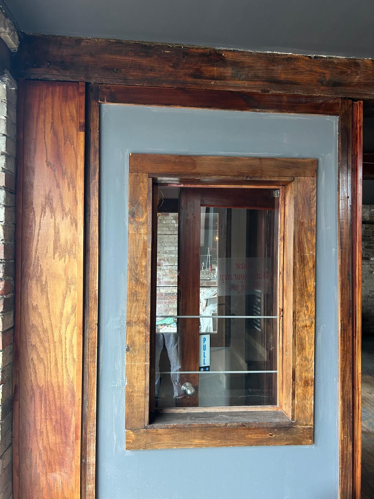 A wooden door with a window in the middle of it.