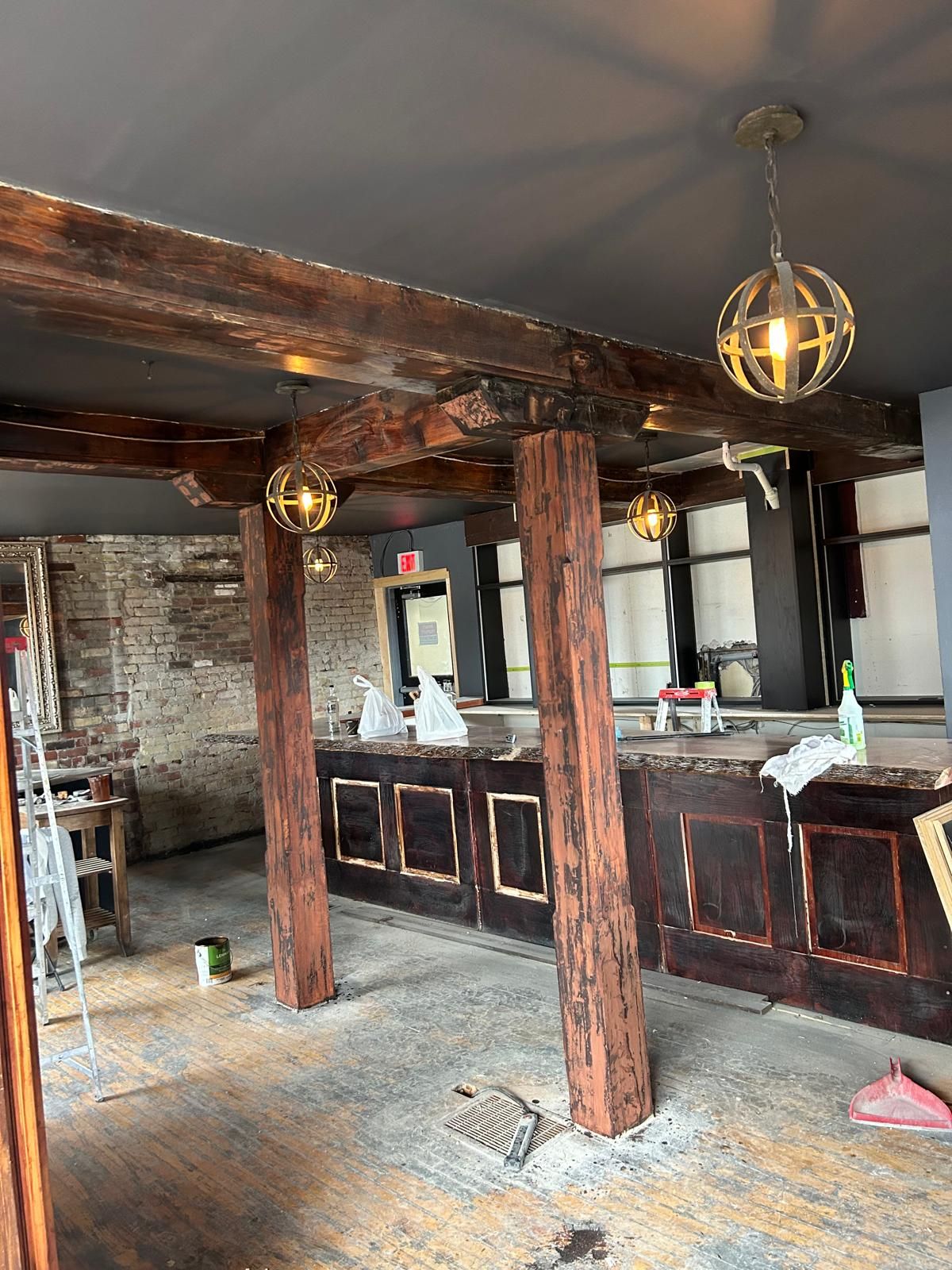 A large empty room with wooden beams and a ceiling light.