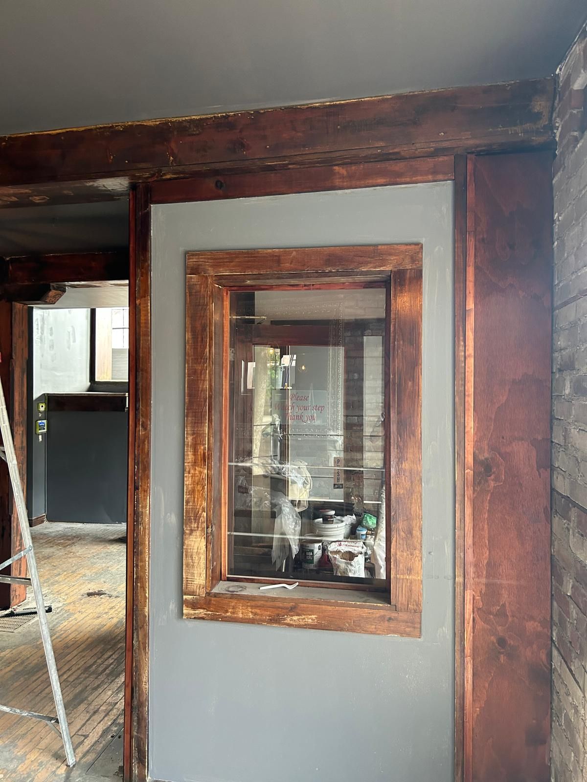 A wooden frame with a window in the middle of a room.