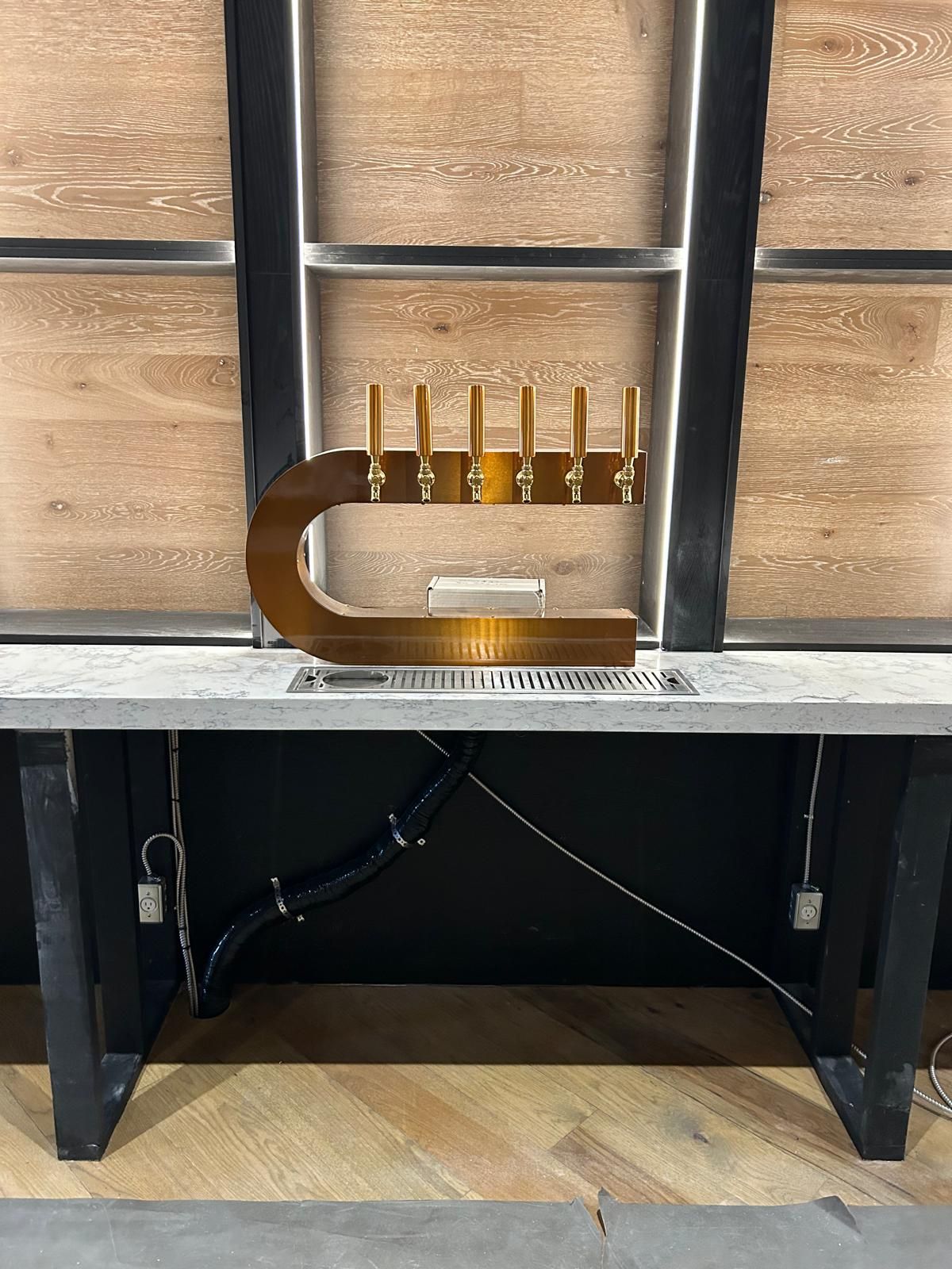 A brass letter c is sitting on top of a wooden table.