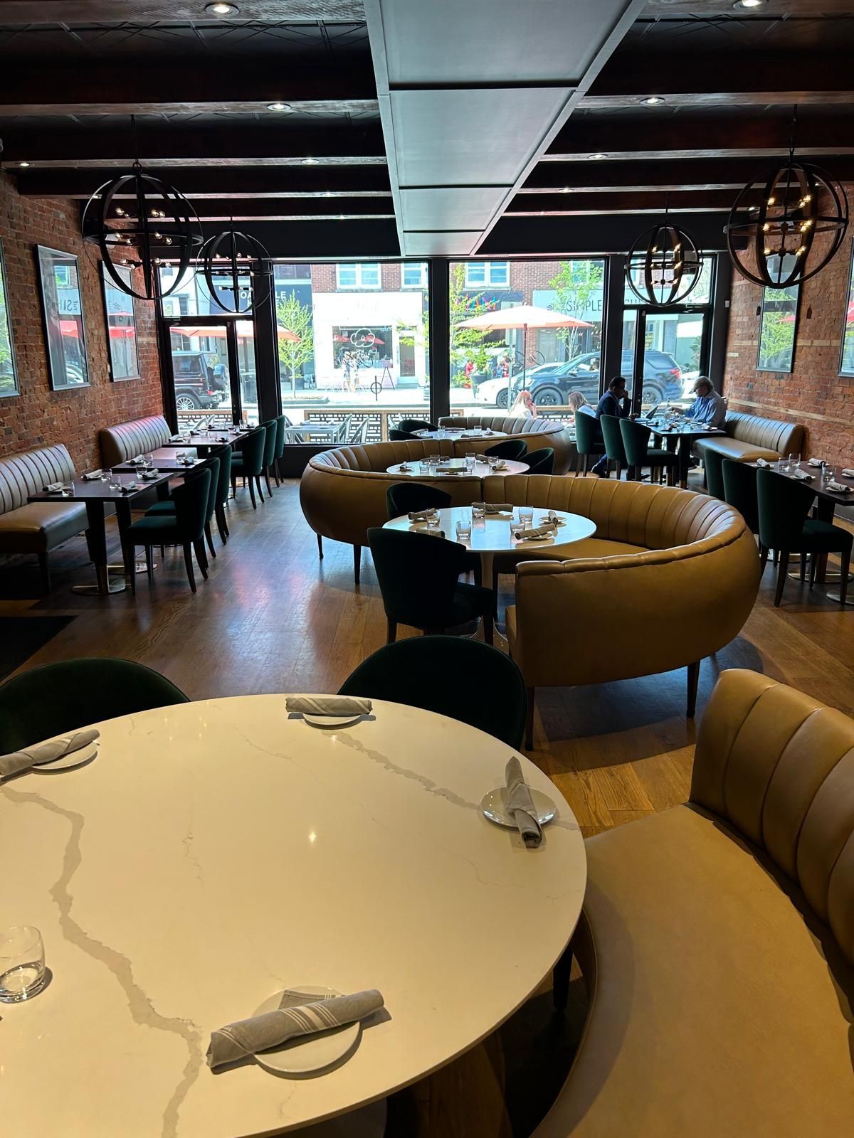 A restaurant with tables and chairs and a large window.