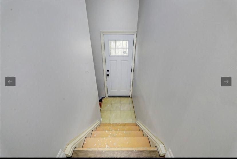 A staircase leading up to a white door in a house.