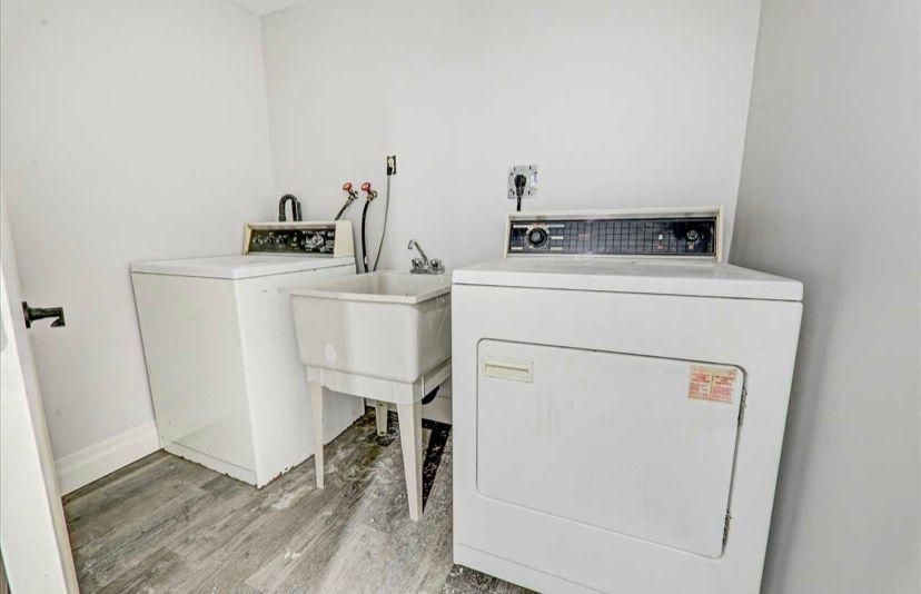 A laundry room with a washer and dryer and a sink.