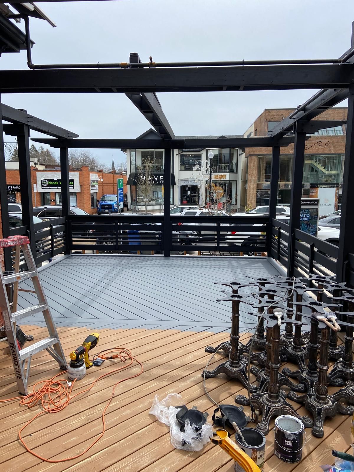 A wooden deck with a ladder and a lot of tables on it.