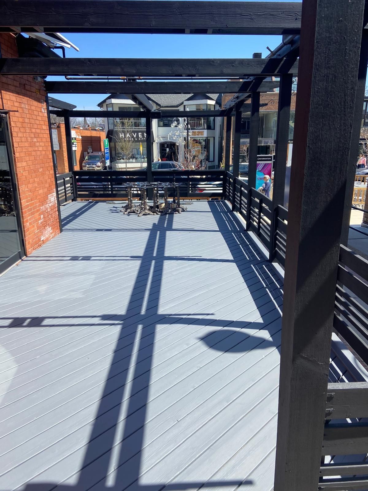 A deck with a pergola and a table and chairs on it