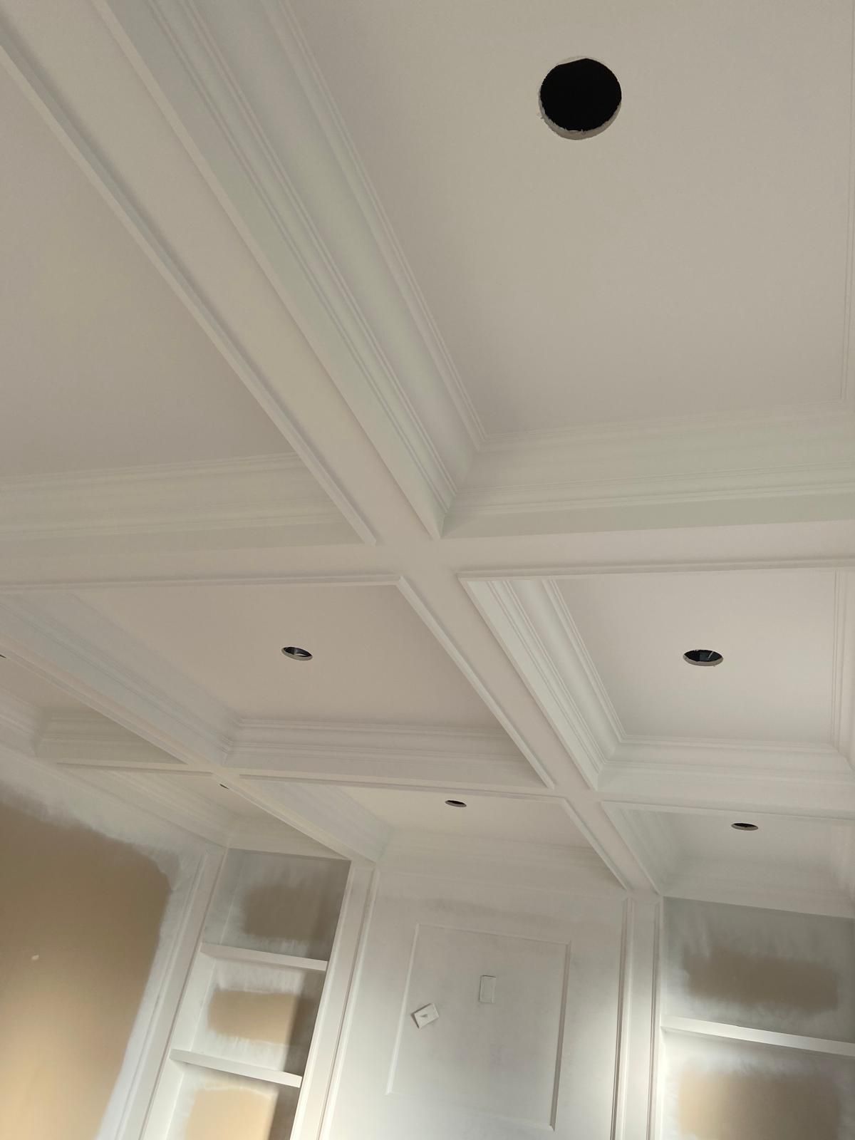 A white ceiling with a black hole in the middle of it