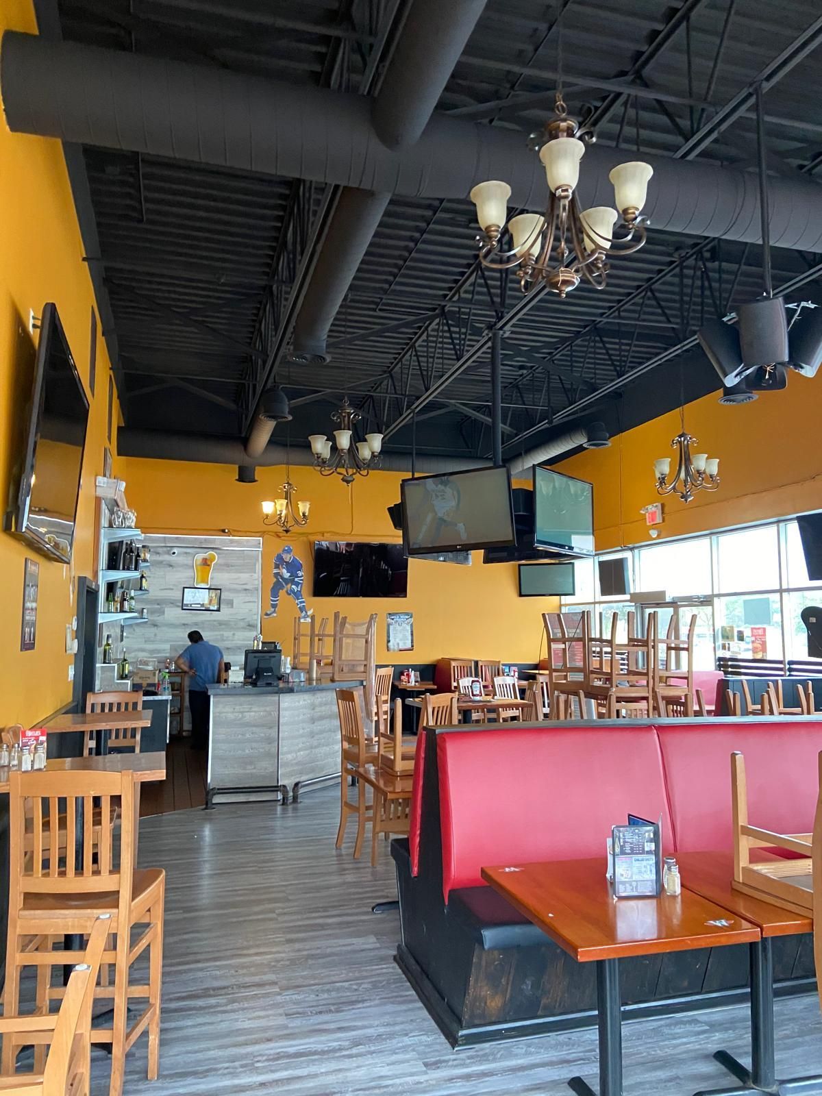 The inside of a restaurant with tables and chairs and a bar.