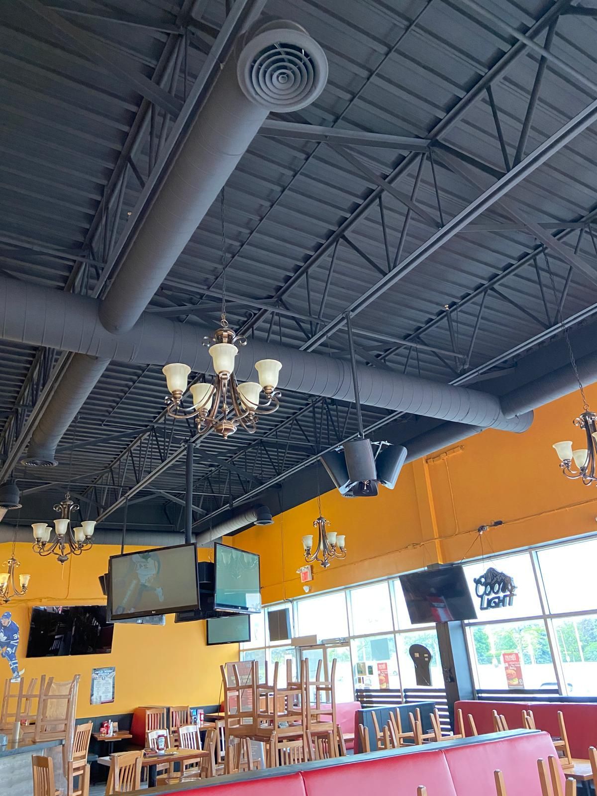A restaurant with tables and chairs and a chandelier hanging from the ceiling.