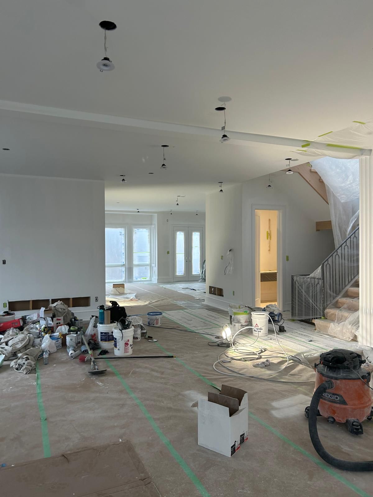 A vacuum cleaner is sitting on the floor of a room under construction.