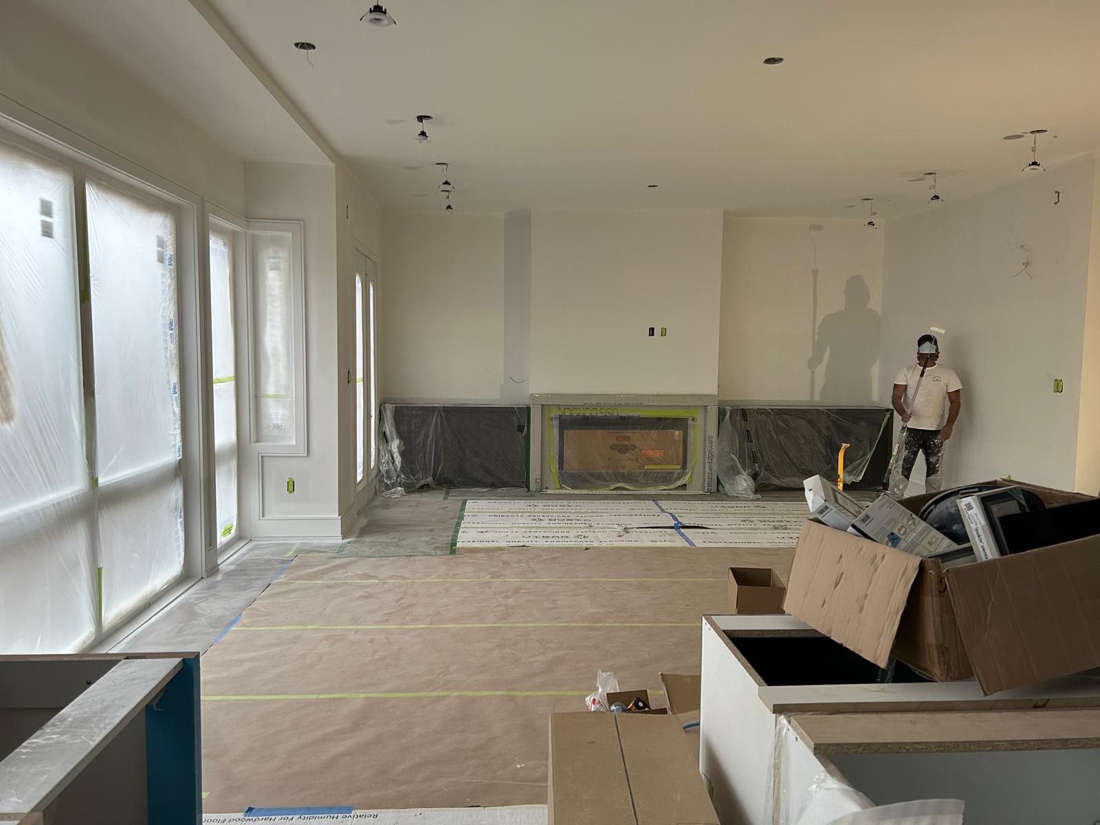A man is standing in a living room with a fireplace.