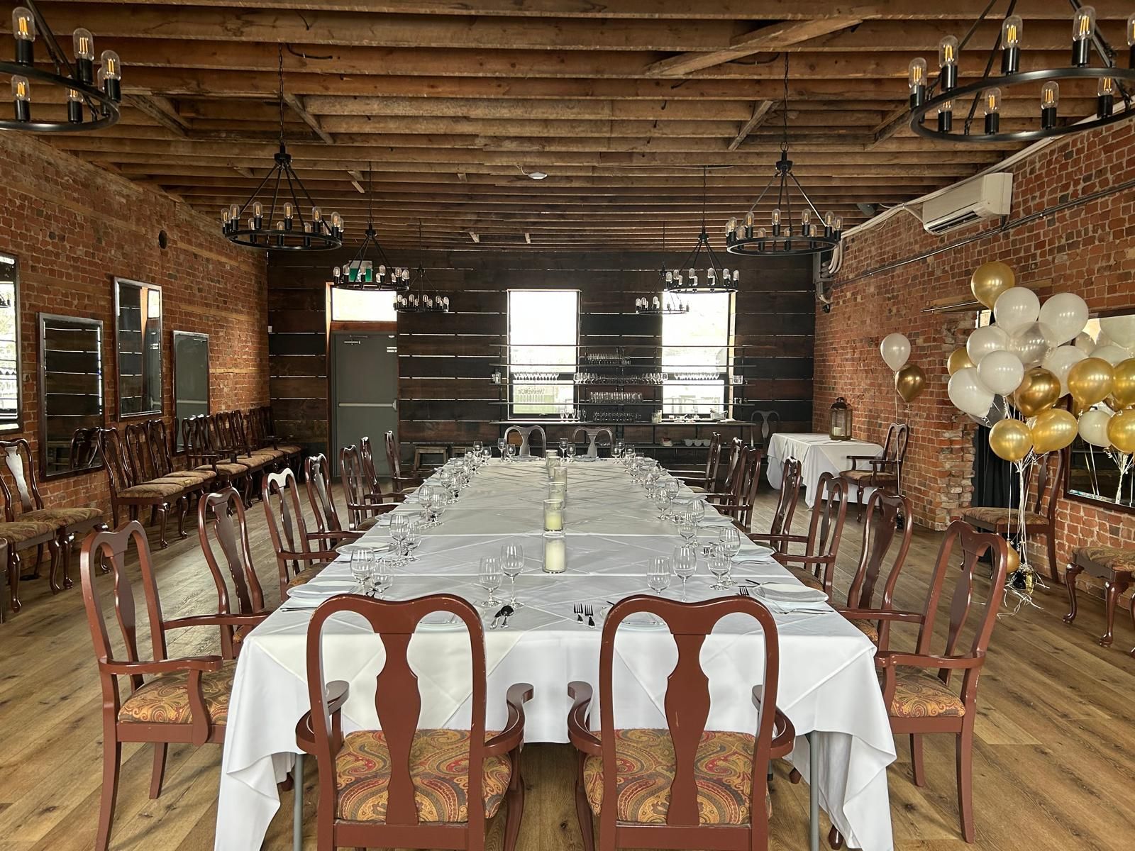 There is a long table and chairs in the middle of the room.