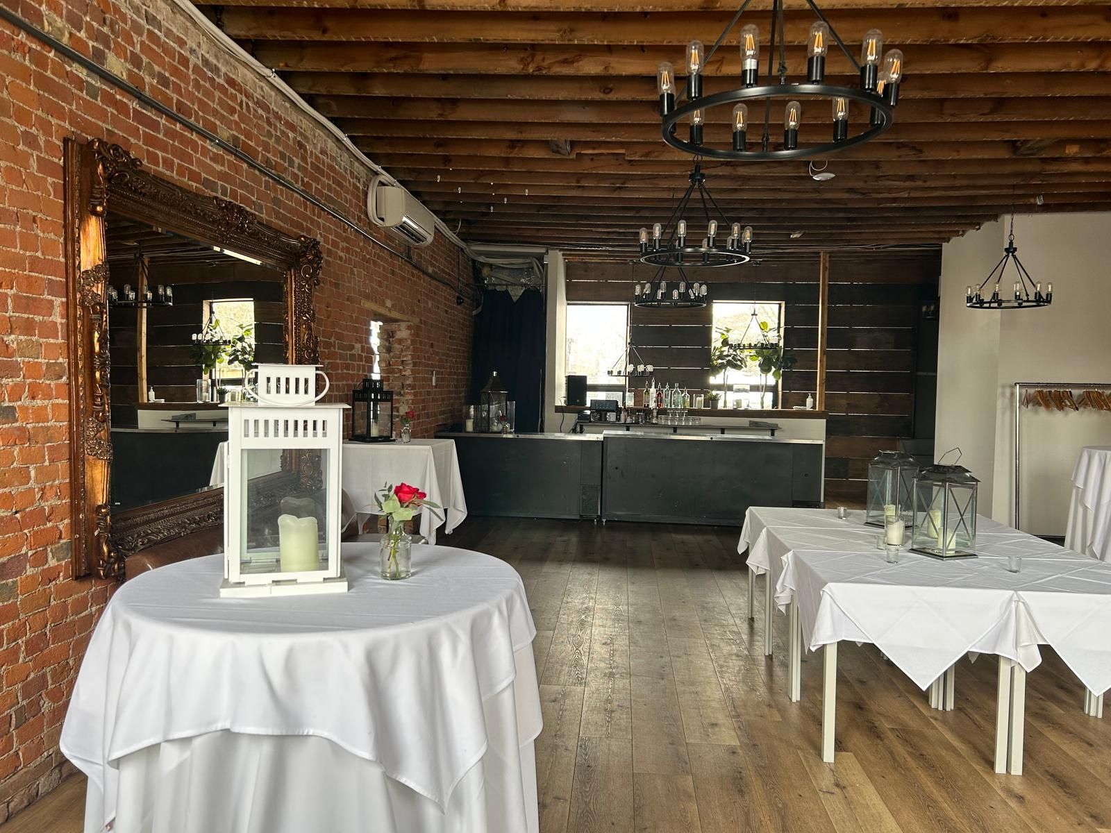 A large room with tables and chairs and a chandelier.