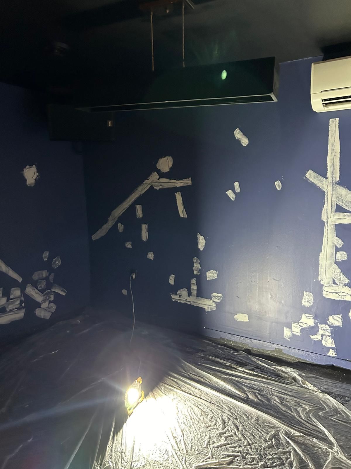A room with blue walls and a light on the floor.