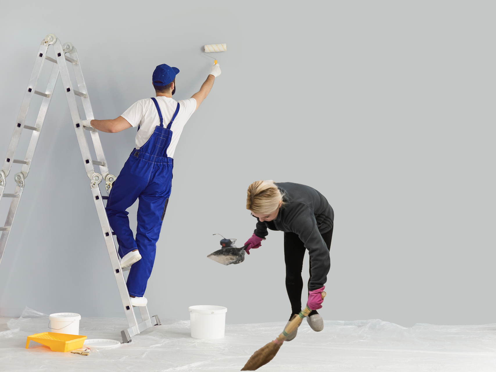 A man and a woman are painting a wall together.