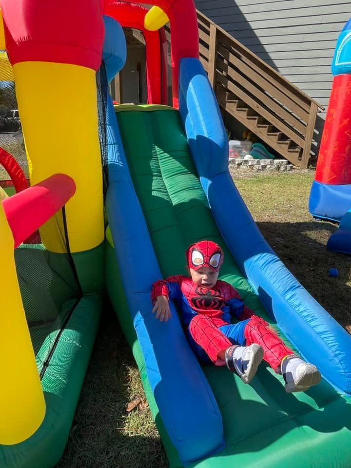 kid in spiderman outfit on slide