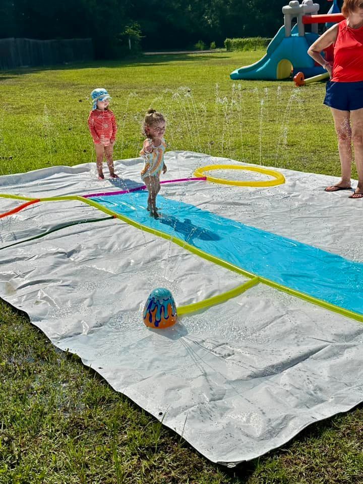 daycare kids outside playing on water slide