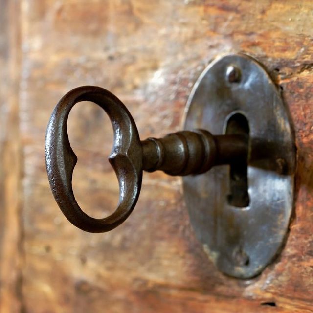 A key in a keyhole on a wooden door
