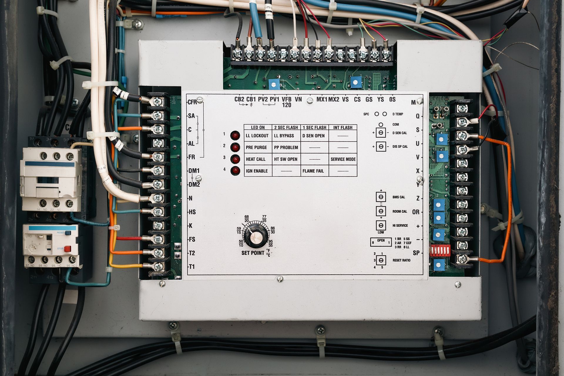 Electrical control panel with wiring, switches, and circuit modules inside an open cabinet