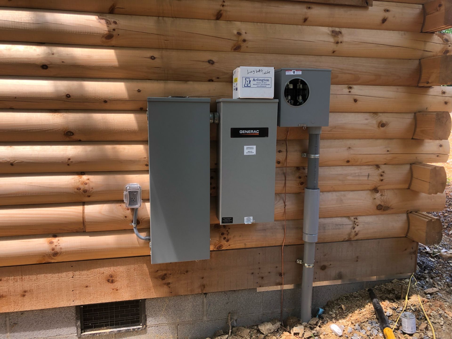 Electrical panel boxes mounted on a wooden cabin exterior.