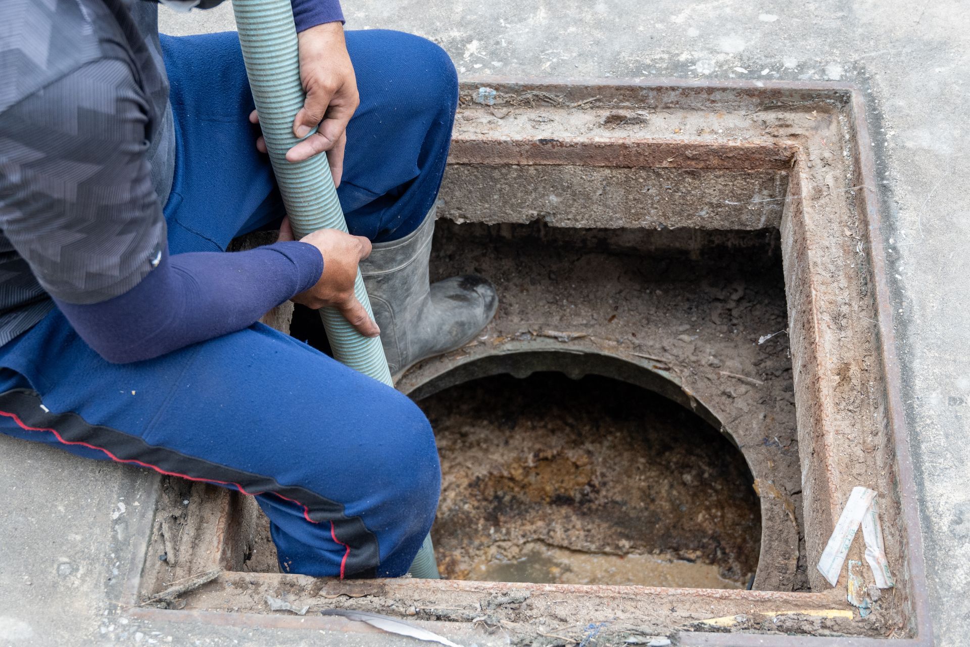 Technician carrying a suction hose for septic service.