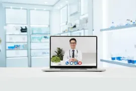 Laptop displaying a doctor on a video call in a bright medical office