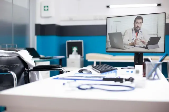 Telemedicine office with a doctor on a video call displayed on a large monitor