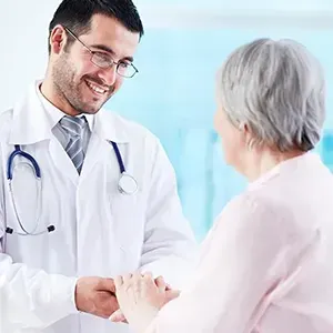 Doctor shaking hands with a patient in a bright clinic office