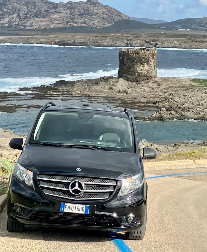 una mercedes benz è parcheggiata in un parcheggio vicino al mare