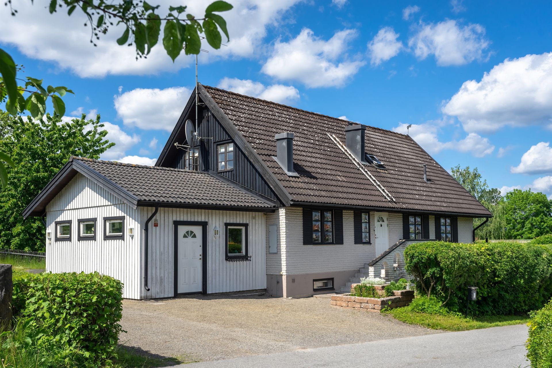 House with white and black exterior under a blue sky