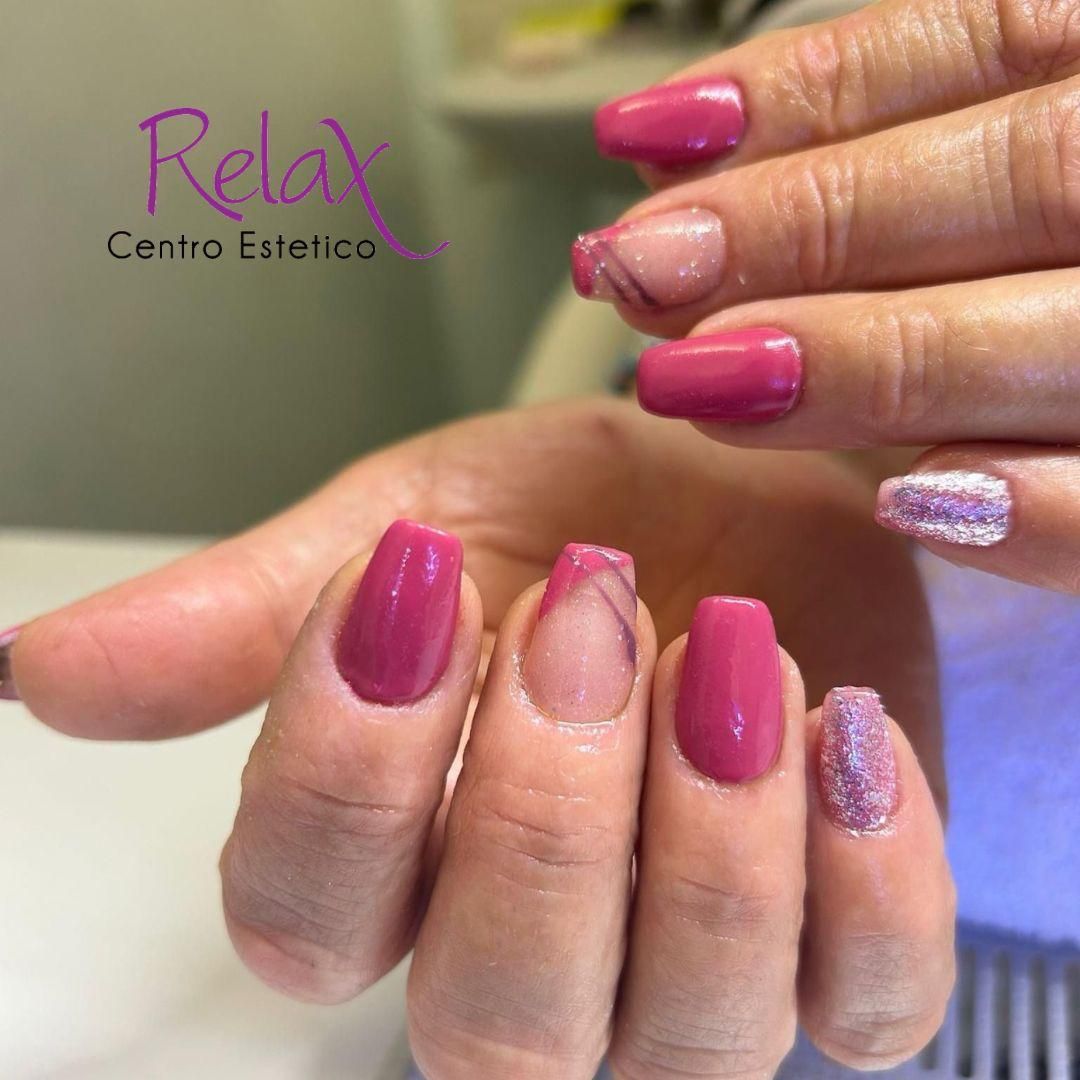 Mani con smalto rosa lucido e glitterato in un salone di bellezza, mentre mostrano il lavoro di manicure eseguito.