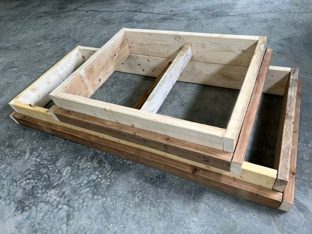 Palettes en bois empilées sur un sol en béton, vues de dessus.