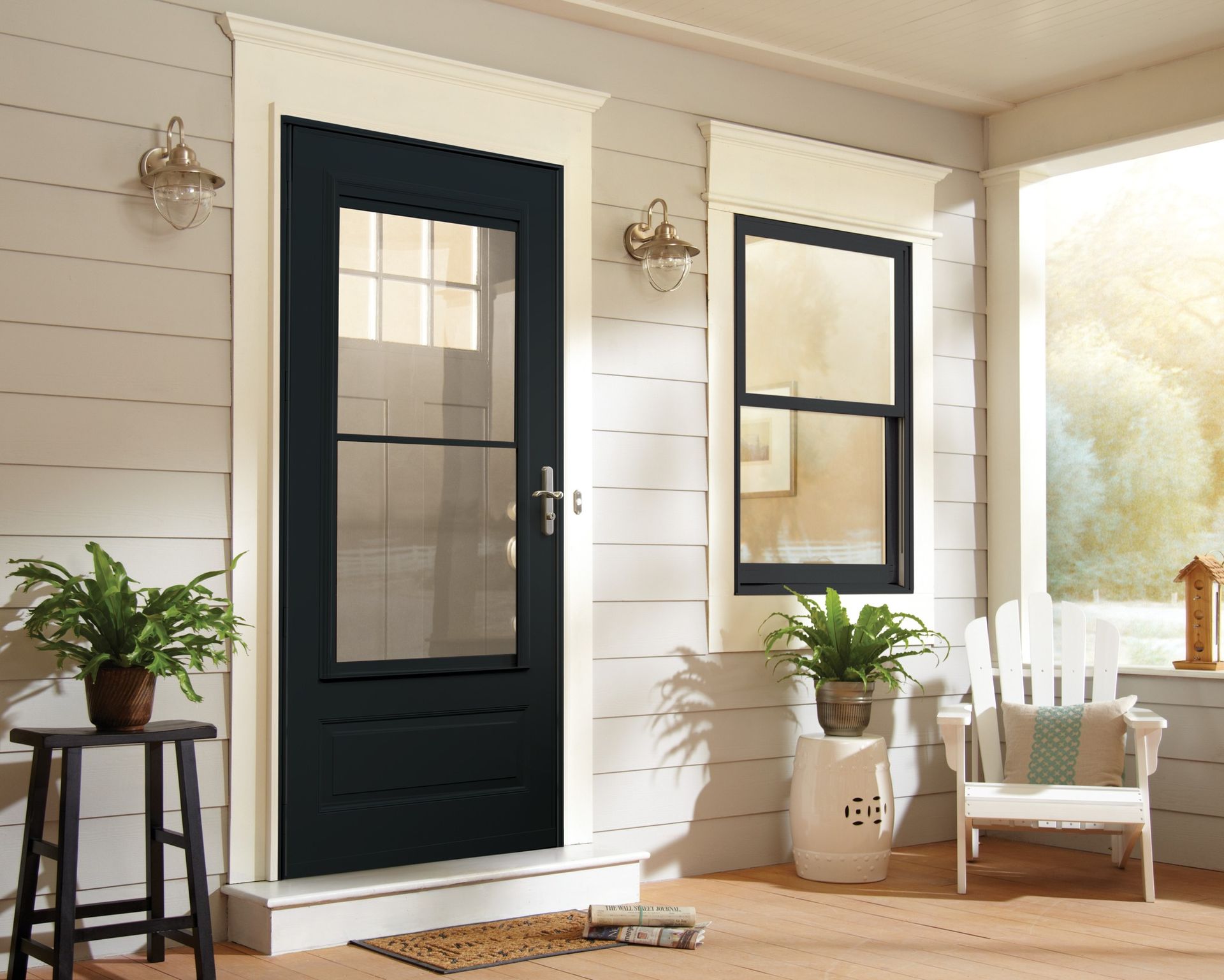 A porch with a black door and two windows