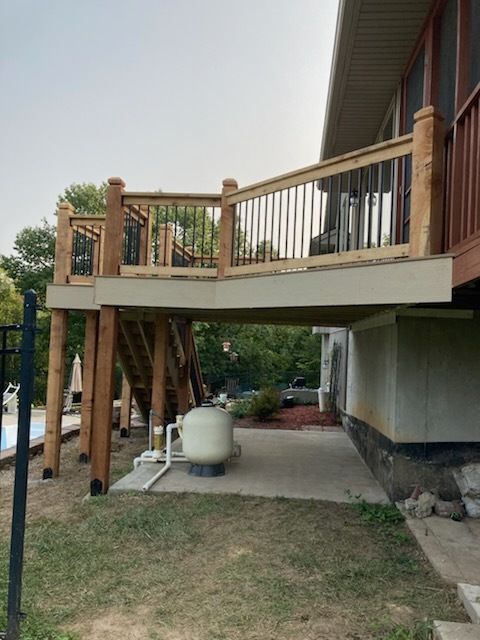 Elevated wooden deck with stairs. Supports are visible. Pool equipment below deck.