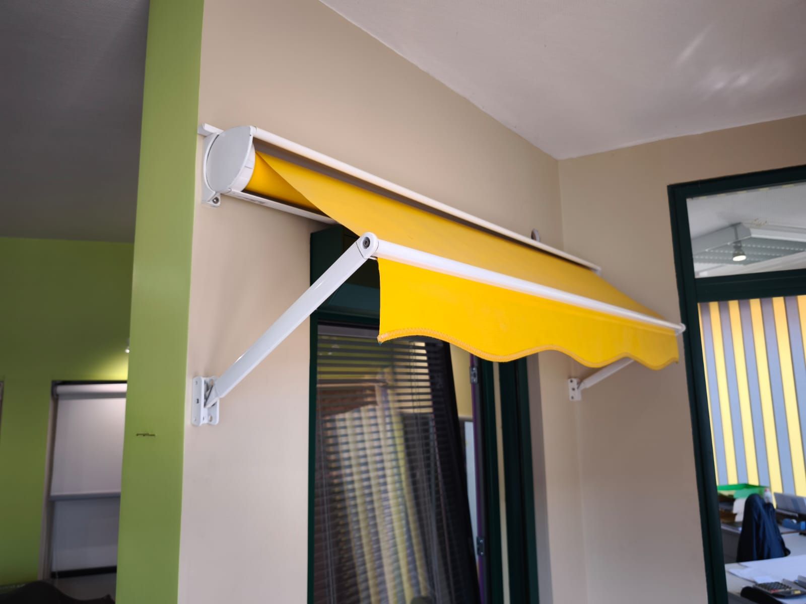 Un store jaune est suspendu au-dessus d'une fenêtre PVC dans une pièce au Havre