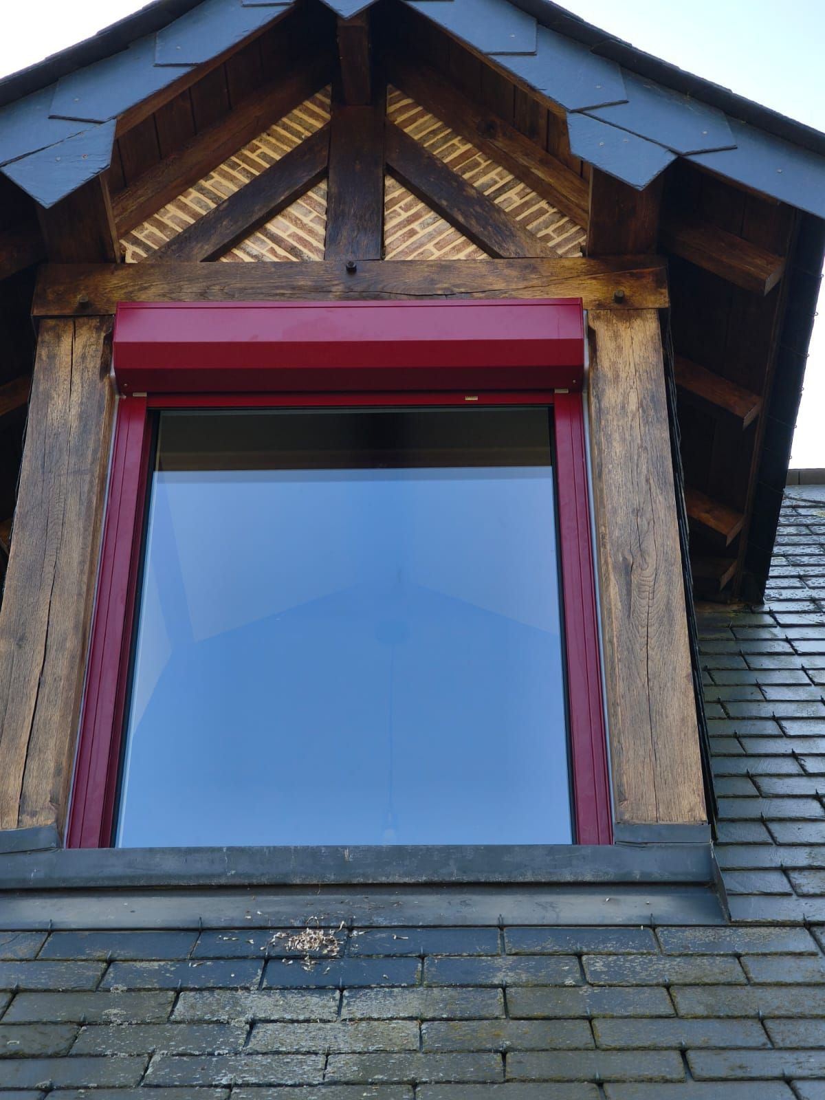 Une fenêtre sur le côté d'un bâtiment avec un cadre rouge