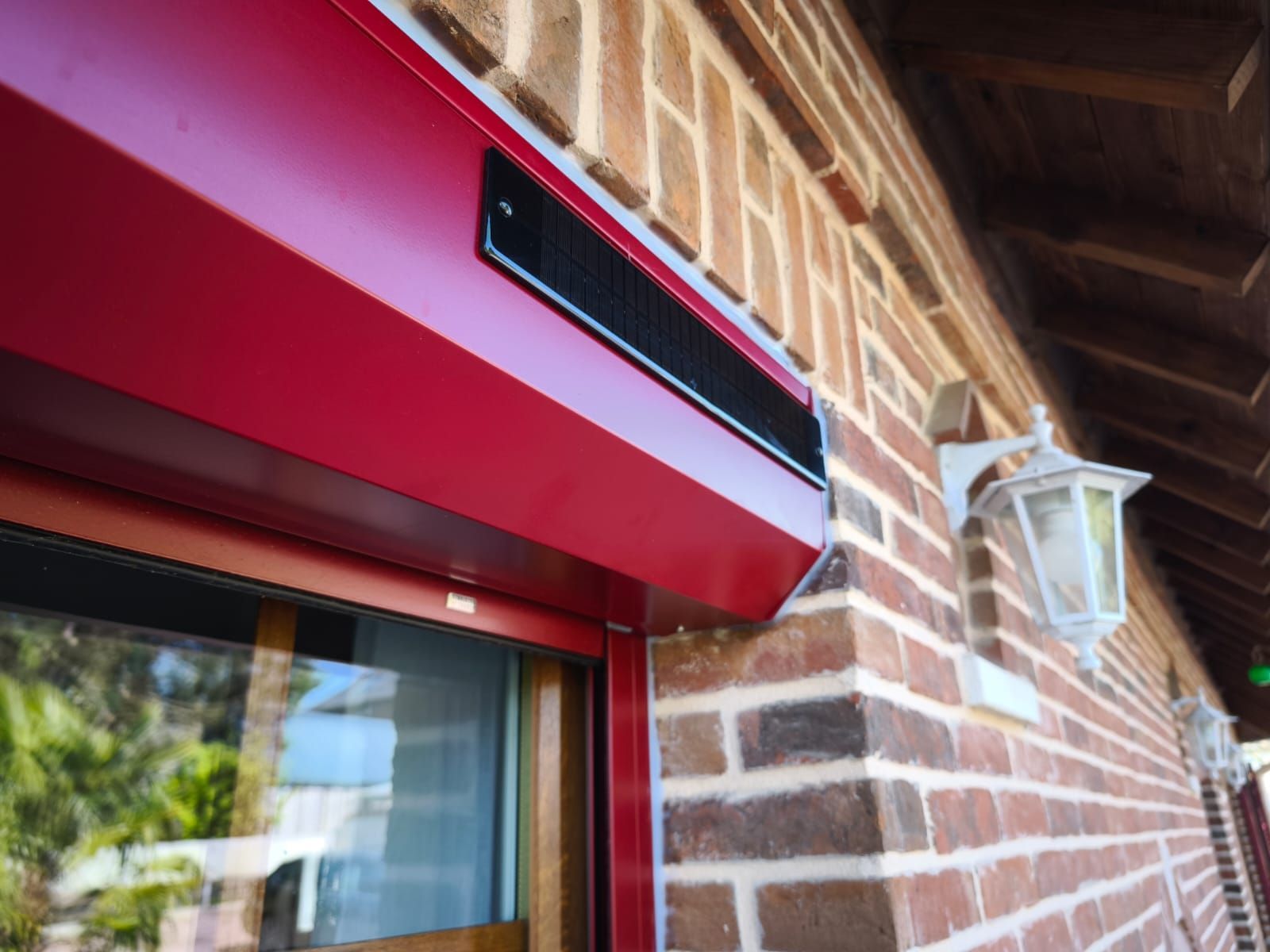 Un bâtiment en briques avec une porte rouge et une lampe sur le côté.
