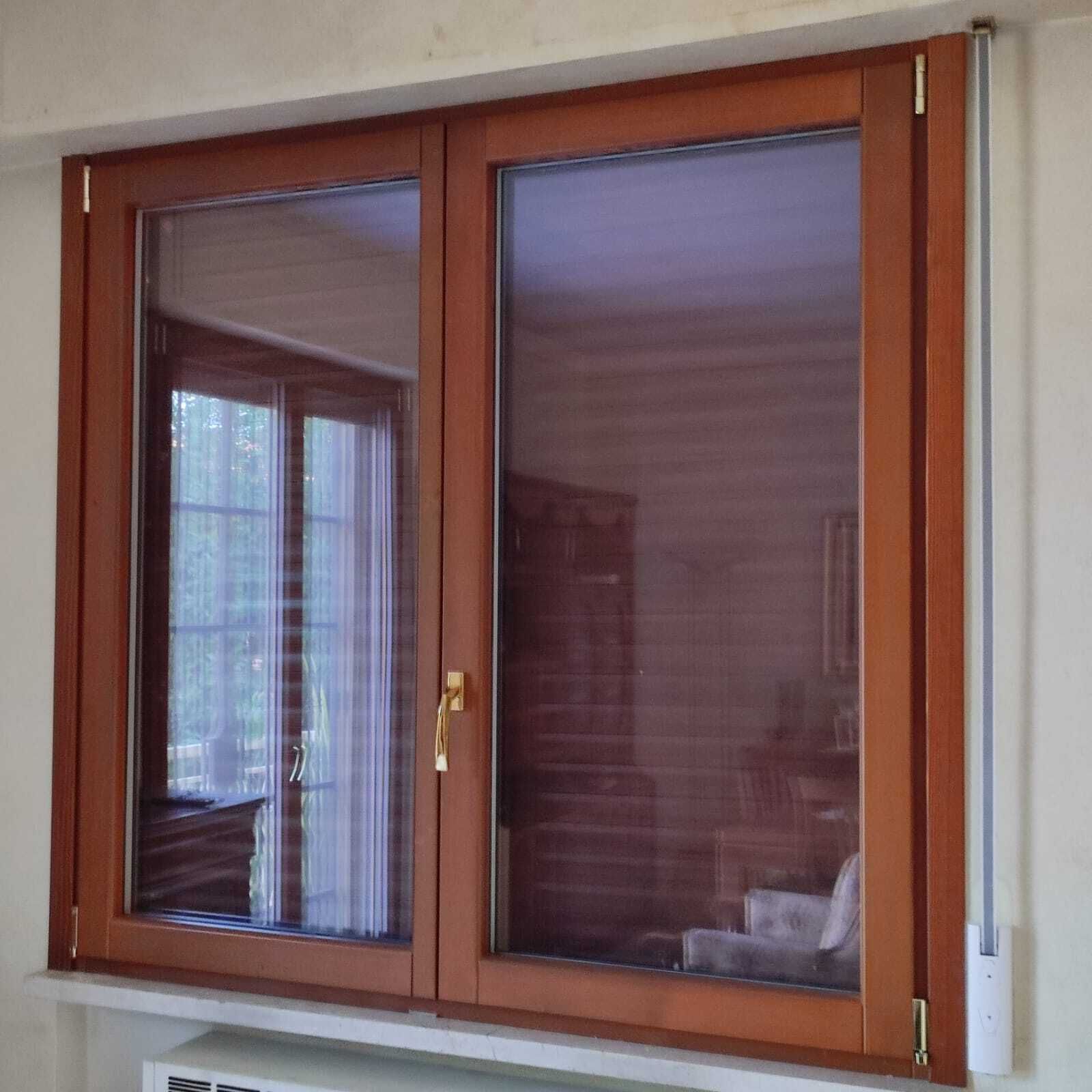Una finestra di legno con il riflesso di una sedia al suo interno