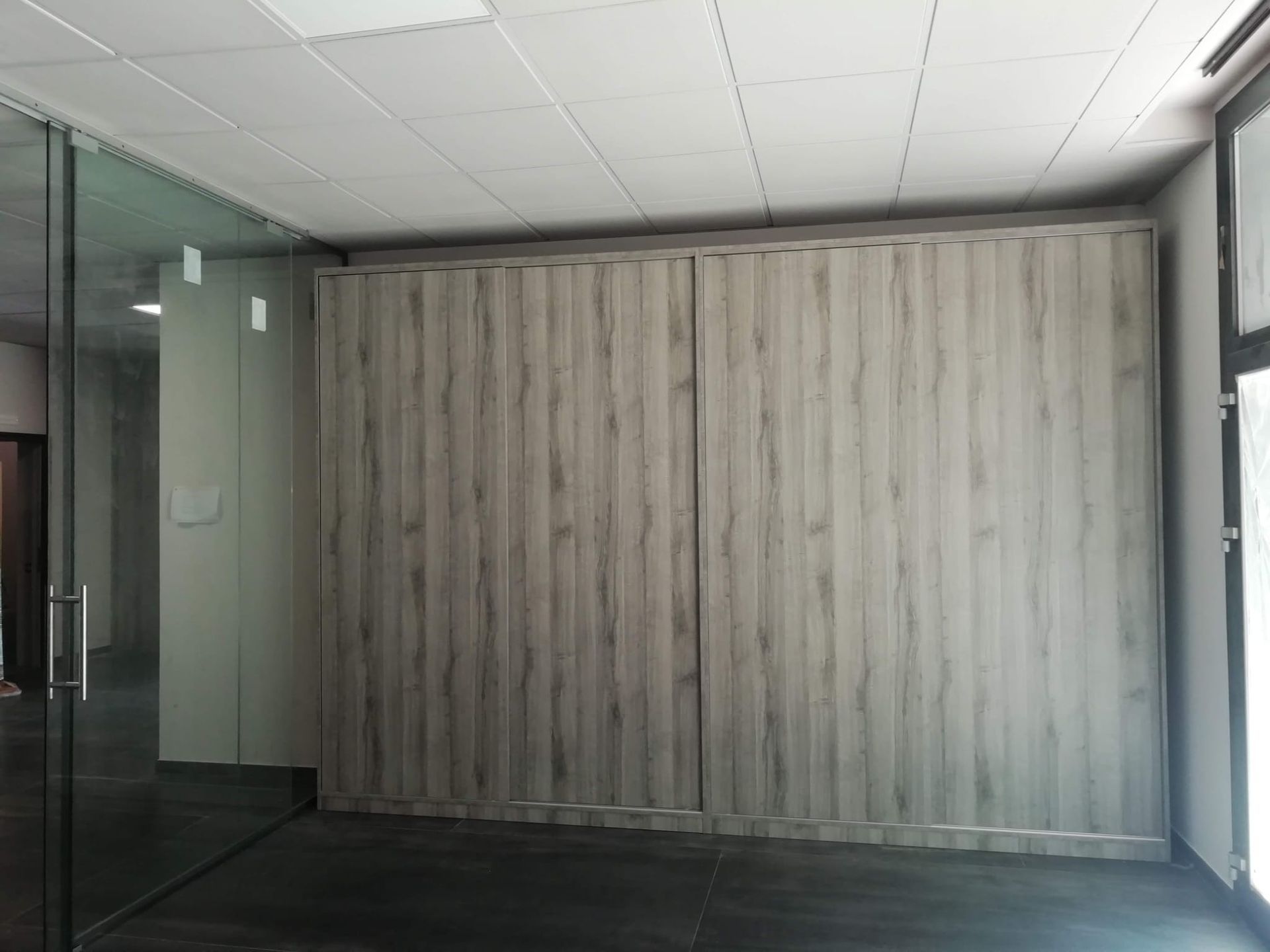 Una stanza con una parete in legno e una porta a vetri.