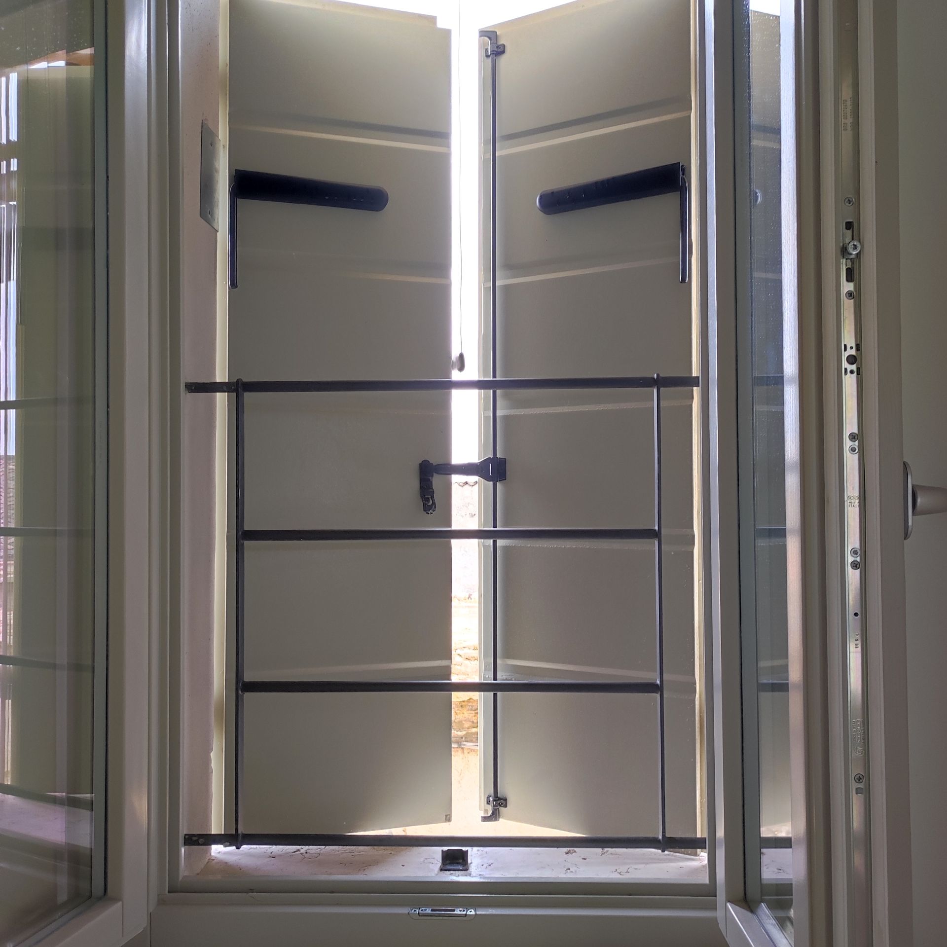 Una porta bianca con una ringhiera nera è aperta