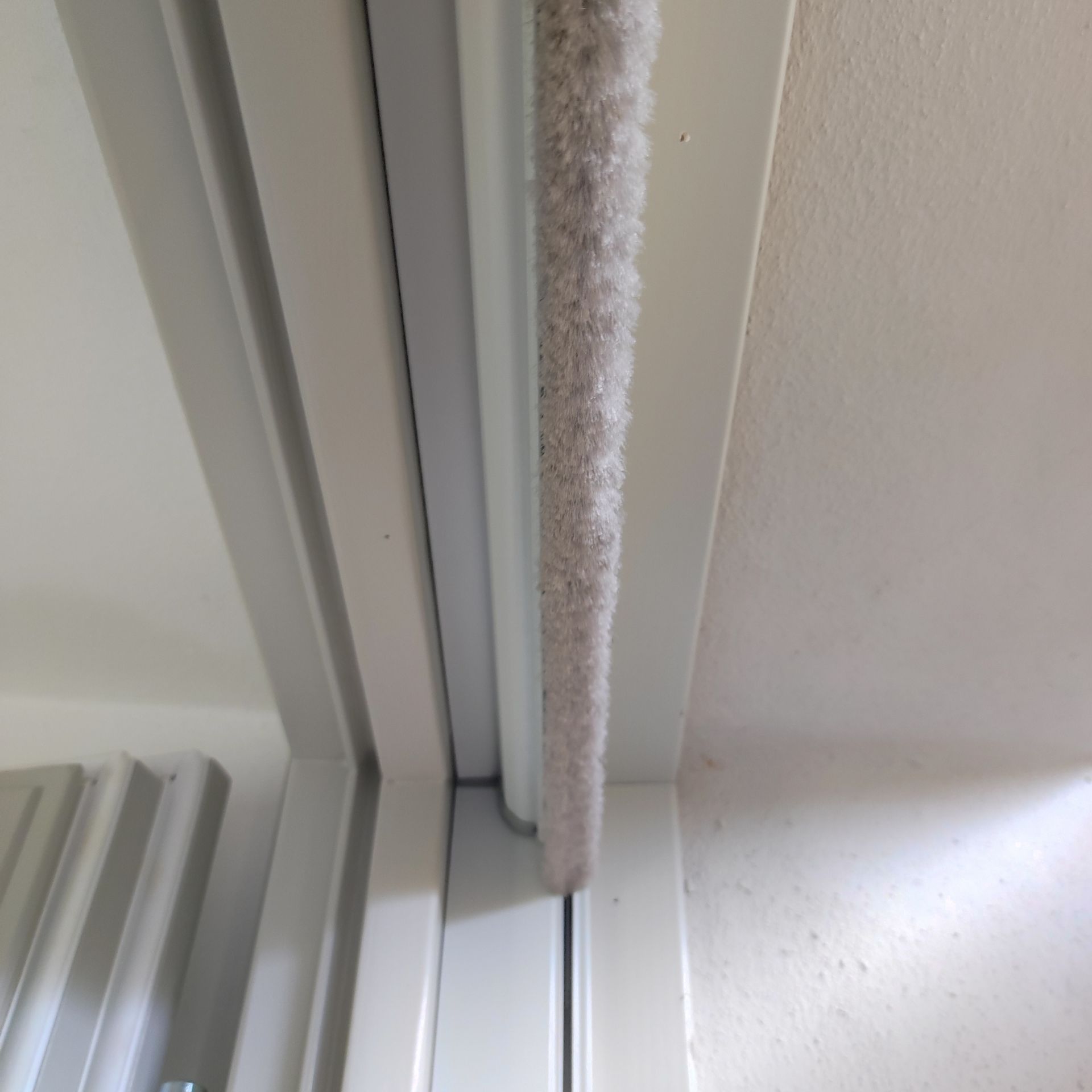 Un primo piano di una porta scorrevole in vetro con una spazzola sopra.