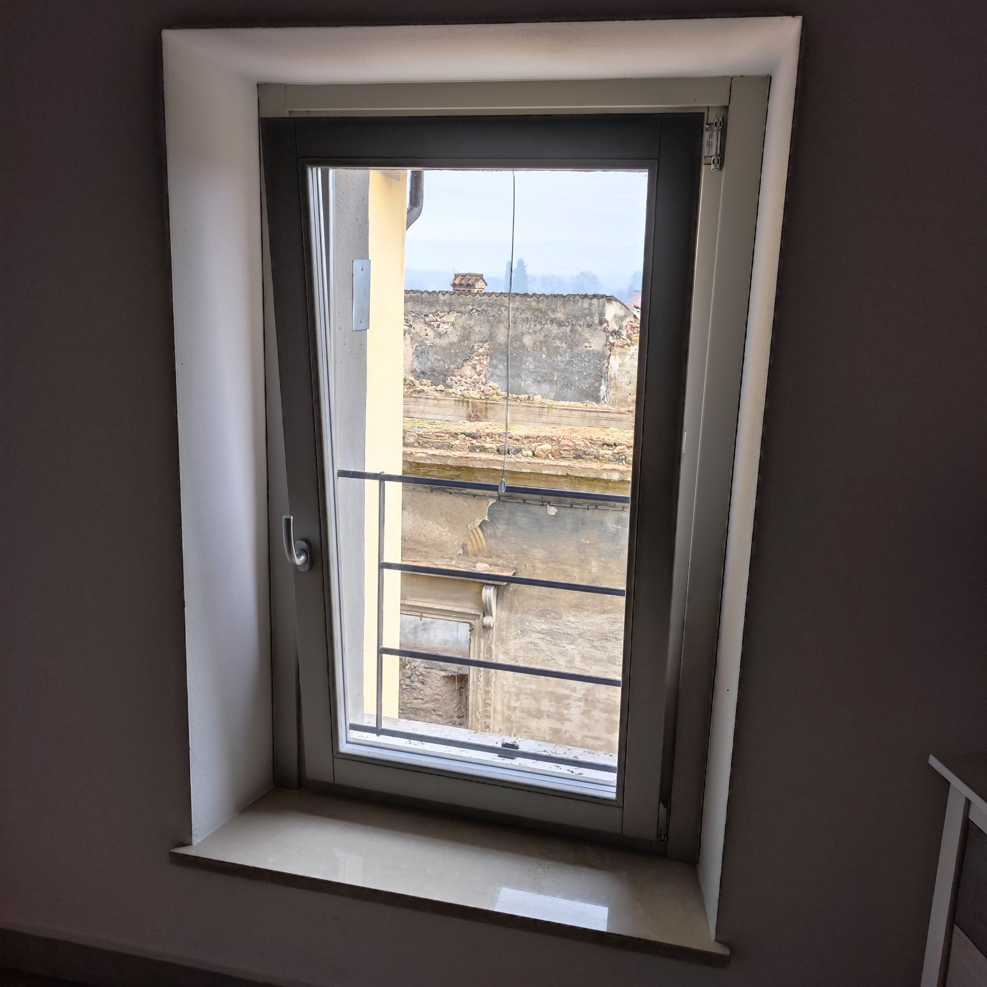 Una finestra in una stanza con vista su un edificio