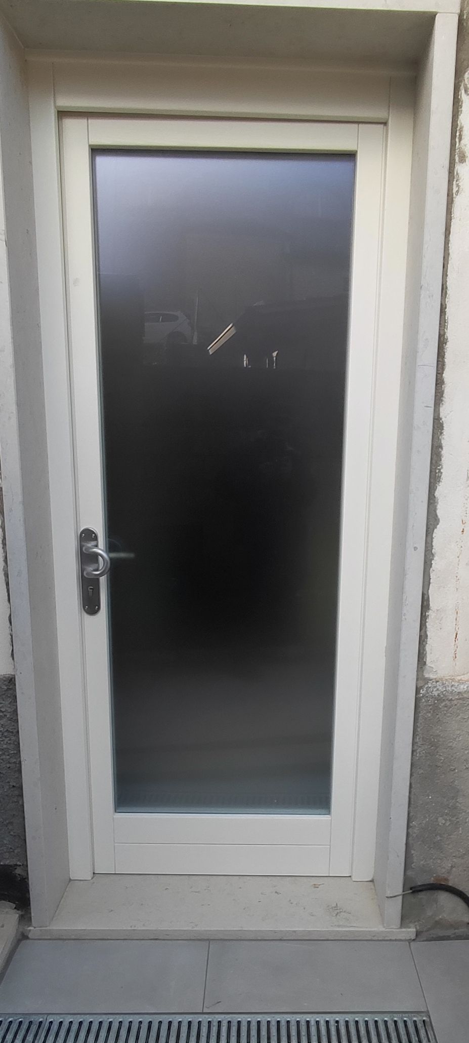 Una porta bianca con una porta di vetro e una serratura.