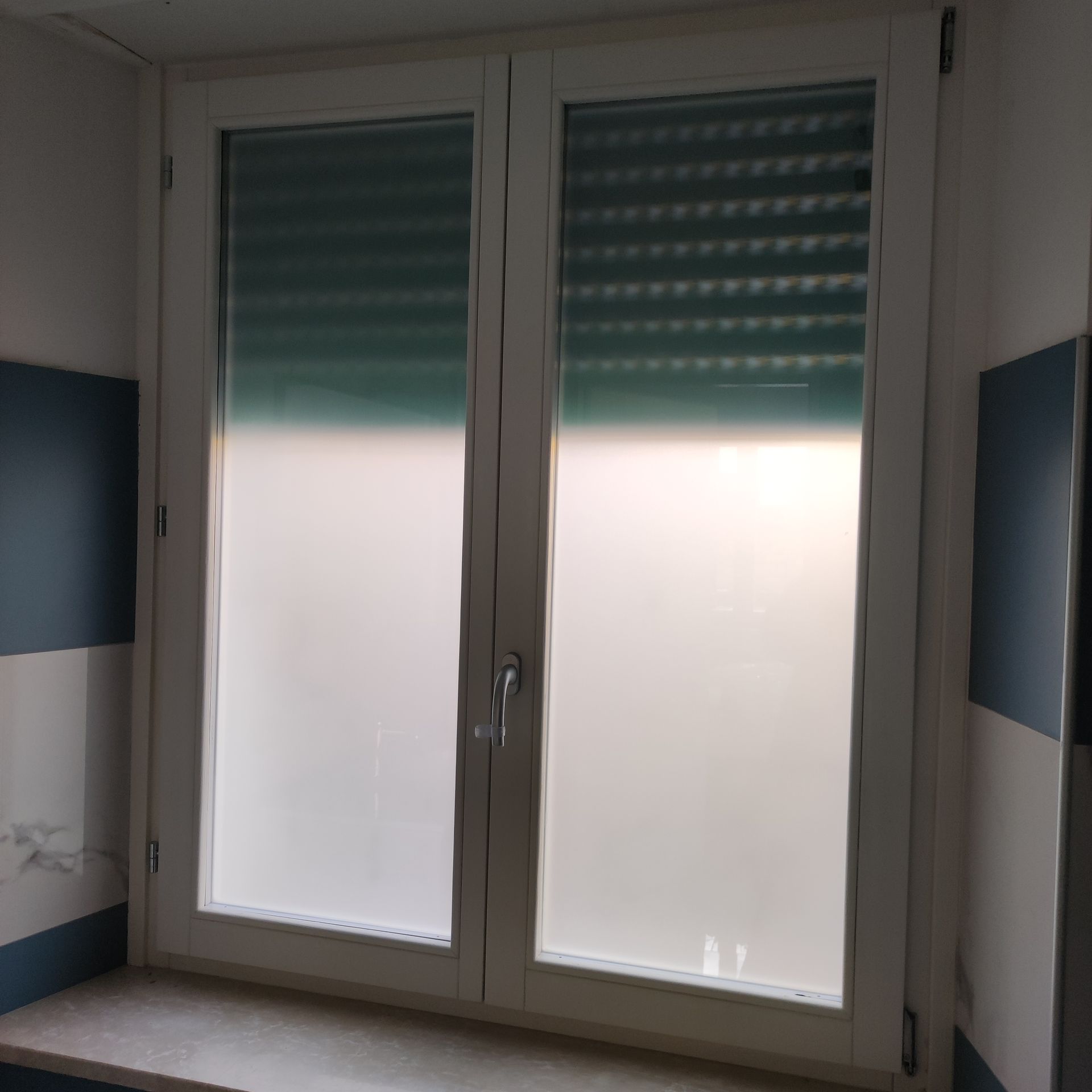 Una finestra con una tenda verde in una stanza