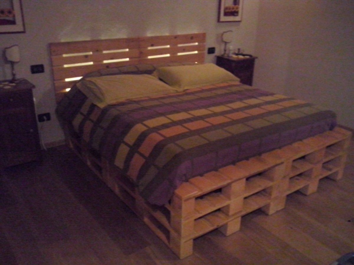Un letto fatto di pallet di legno in una camera da letto