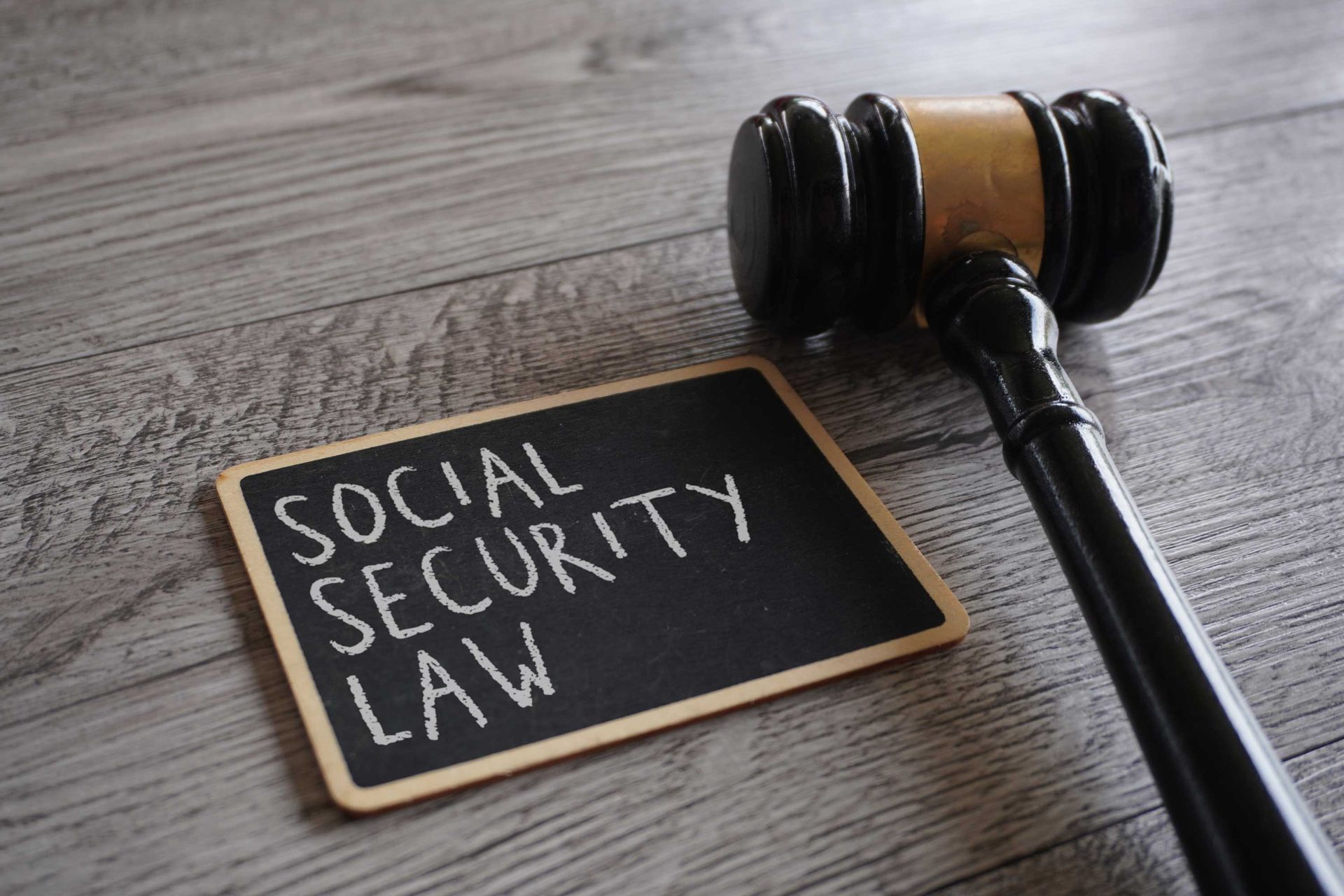 Judge’s gavel beside a small chalkboard sign reading “Social Security Law.