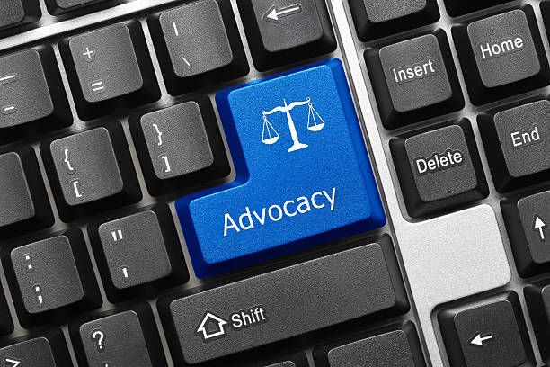 Computer keyboard with a blue key labeled Advocacy and a scale icon symbolizing justice.
