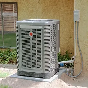 Outdoor air conditioner unit beside a stucco house wall with visible electrical conduit