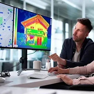 Team reviewing a colorful heat map on a monitor in a bright office setting
